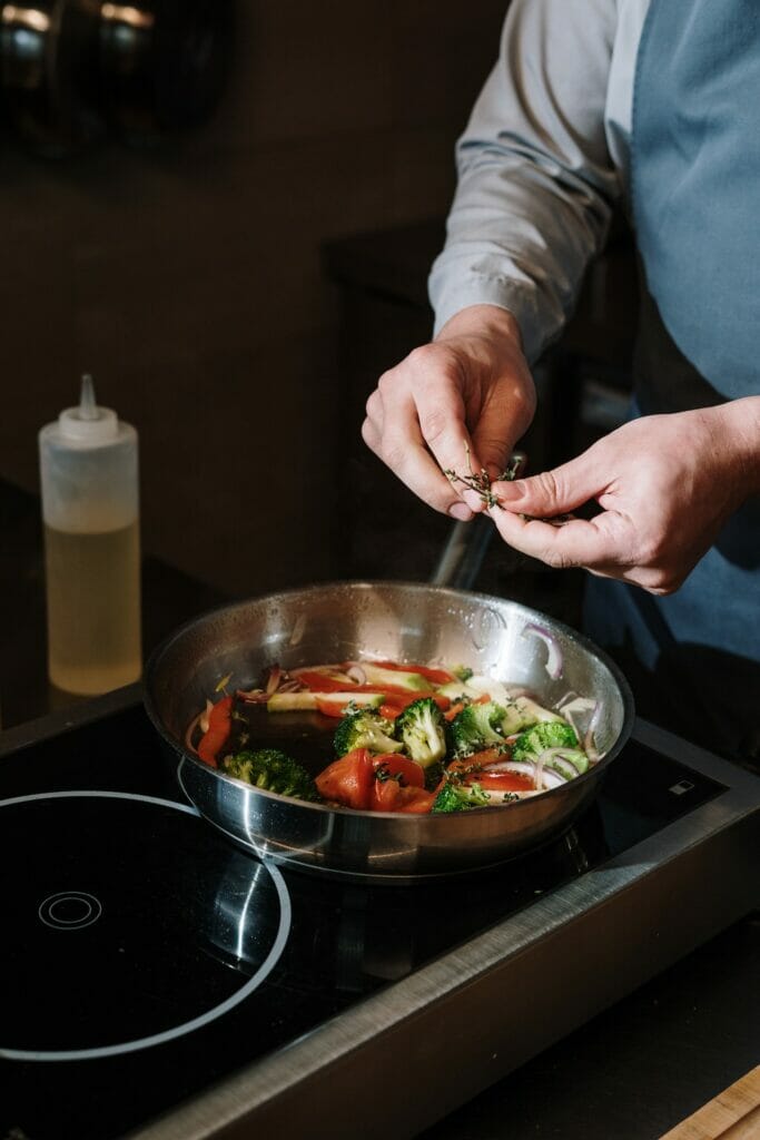 frying cooking method vegetables in a frying pan adding herbs